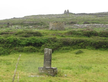 Killeany, Aran Mor, County Galway, cross shaft with round tower stump and  Teampall Bheanáin in the background